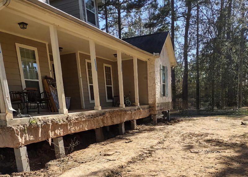 a house with porches and columns in the dirt