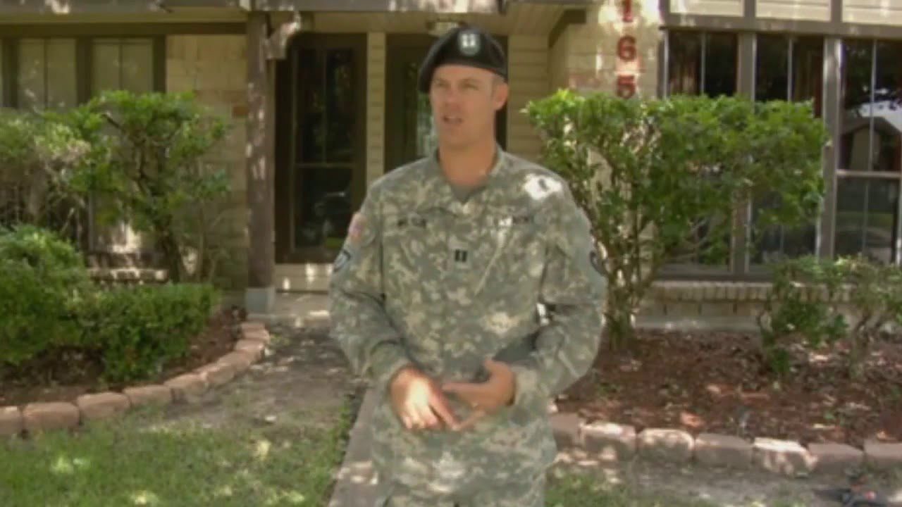 a man in uniform standing in front of a house