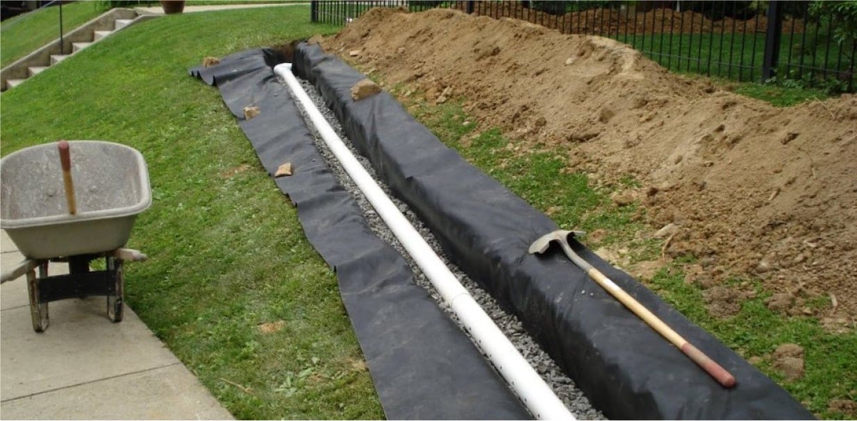 a garden hose laying on the ground next to a wheelbarrow