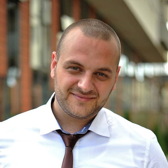 a man in a tie is smiling for the camera