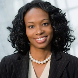 a woman wearing a suit and pearls necklace