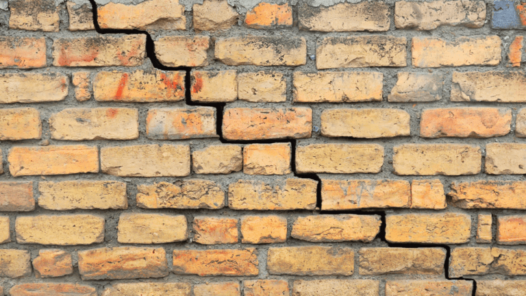 an old brick wall with cracks in it