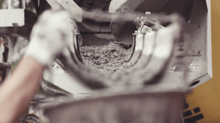 a person is pouring cement into a mixer