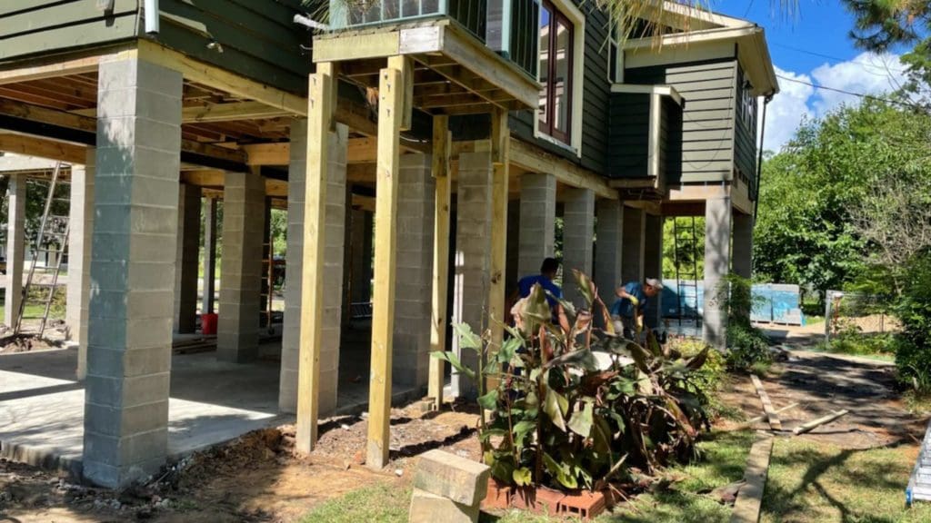 two men working on a house under construction