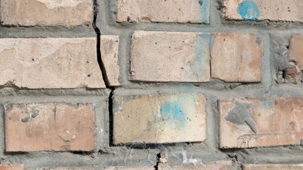 a close up of a brick wall with blue paint