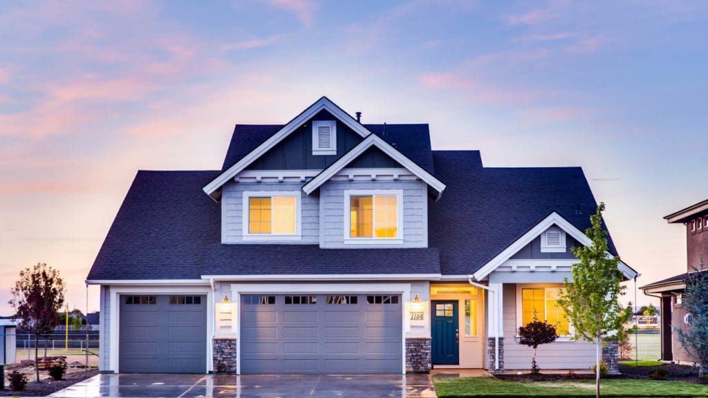 a large house with two garages in front of it