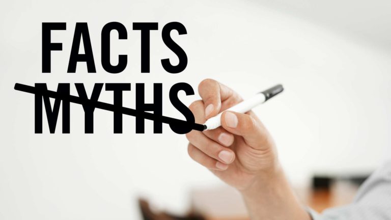 a hand writing the word fact with a marker