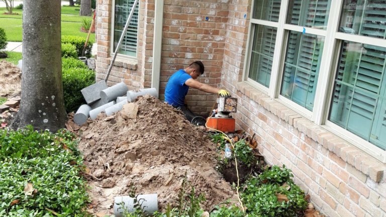a man is digging dirt in front of a house