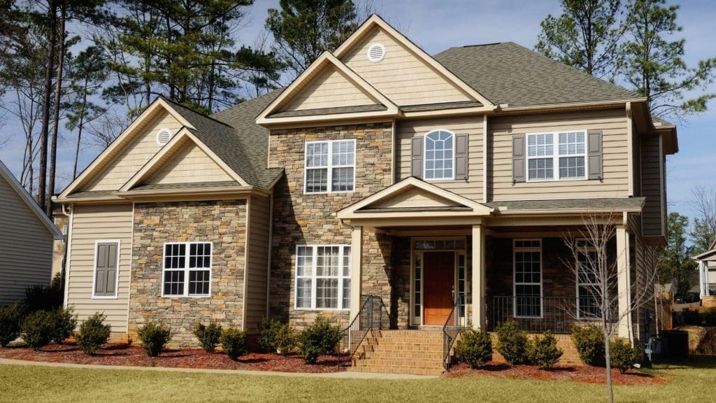 a large house with two story windows and brown siding