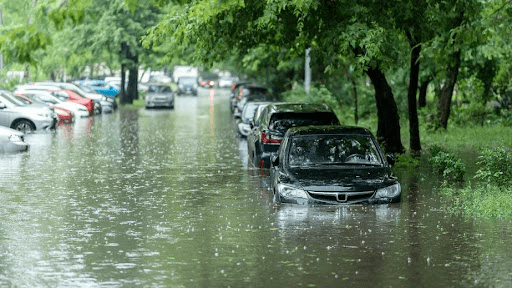 cars are parked on the side of a flooded street