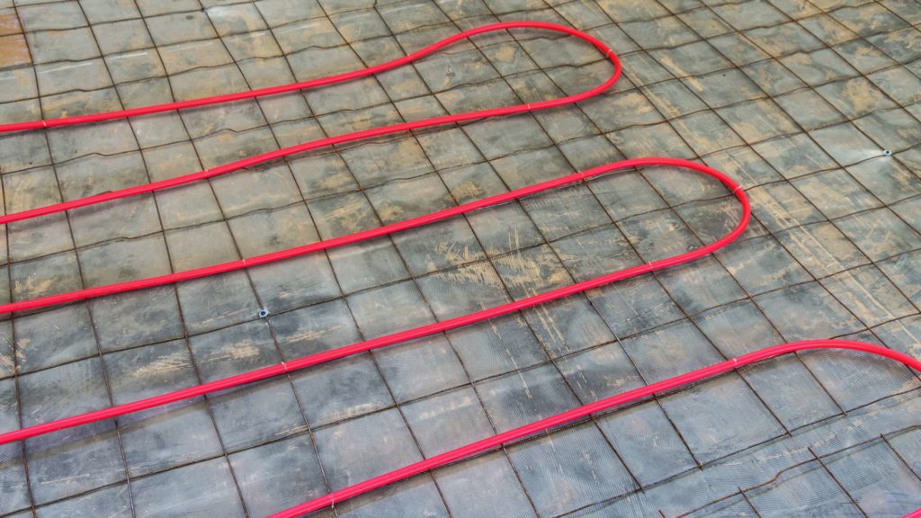 a red heating mat on the ground with wires attached to it