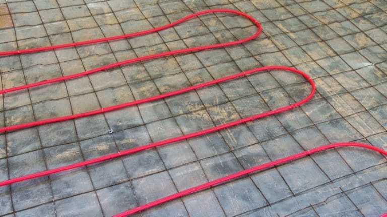 a red heating mat on the ground with wires attached to it