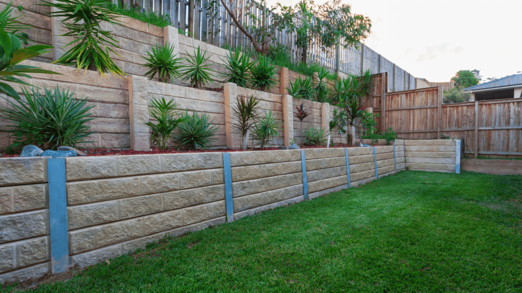 a fenced in backyard with grass and plants
