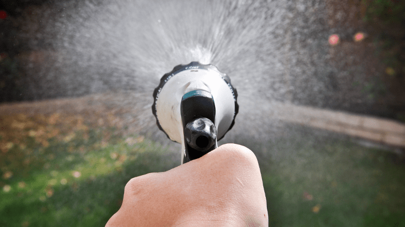 a hand is sprinkling water on a fire hydrant