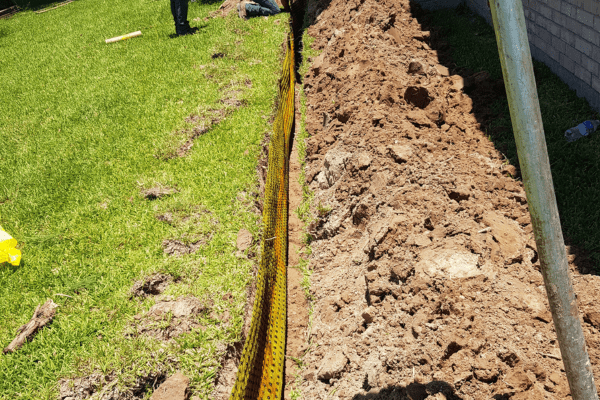 two people are working in the yard with dirt