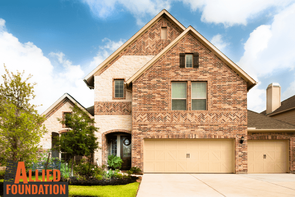 a brick house with a yard sign in front of it